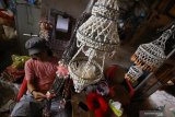 Perajin menyelesaikan pembuatan kerajinan dari bahan limbah cangkang kerang di Kampung Tambak Deres, Surabaya, Jawa Timur, Selasa (6/10/2020). Cangkang kerang yang diolah menjadi berbagai macam kerajinan seperti lampu hias, tirai, pigura, miniatur hewan, gantungan kunci, bros dan lain-lainnya tersebut dijual dengan harga mulai Rp20.000 hingga Rp500.000. Antara Jatim/Moch Asim/zk.