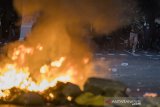 Demonstran melempar batu saat unjuk rasa di Bandung, Jawa Barat, Rabu (7/10/2020). Unjuk rasa menolak UU Cipta Kerja tersebut berakhir ricuh.  ANTARA JABAR/M Agung Rajasa/agr