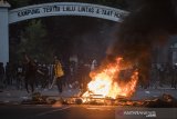 Demonstran melempar batu saat unjuk rasa di Bandung, Jawa Barat, Rabu (7/10/2020). Unjuk rasa menolak UU Cipta Kerja tersebut berakhir ricuh.  ANTARA JABAR/M Agung Rajasa/agr