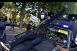 Pengunjuk rasa menghadang mobil polisi saat mengikuti aksi Bali Tidak Diam di Denpasar, Bali, Kamis (8/10/2020). Aksi yang diikuti ribuan massa tersebut dilakukan untuk menolak Undang-Undang Cipta Kerja. ANTARA FOTO/Fikri Yusuf/nym