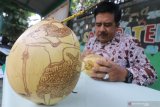 Perajin gambar wayang pada buah kelapa FX Luhkita Heru menyelesaikan karyanya di Kota Kediri, Jawa Timur, Jumat (9/10/2020). Sepasang buah kelapa gading bergambar wayang tersebut dijual seharga Rp250.000 sebagai pelengkap tradisi Tingkeban atau upacara selamatan usia kandungan 7 bulan anak pertama pada masyarakat Jawa. Antara Jatim/Prasetia Fauzani/zk