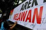 Pengguna jalan membubuhkan tanda tangan di spanduk petisi yang dipajang di depan Gedung DPRD Malang, Jawa Timur, Jumat (9/10/2020). Petisi untuk menolak anarkisme tersebut sengaja dipasang sebagai bentuk keprihatinan atas berlangsungnya demonstrasi Undang -undang Cipta Kerja atau Omnibus Law yang berbuntut kerusuhan. Antara Jatim/Ari Bowo Sucipto/zk
