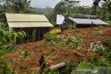 Warga melihat material tanah longsor yang menimbun jalan dan rumah di Kampung Cikidang, Desa Kawitan, Kecamatan Salopa, Kabupaten Tasikmalaya, Jawa Barat, Senin (12/10/2020). Curah hujan yang tinggi di Tasikmalaya mengakibatkan satu pabrik kayu dan satu rumah serta jalur alternatif selatan tertimbun tanah longsor sehingga tidak bisa dilalui kendaraan. ANTARA JABAR/Adeng Bustomi/agr