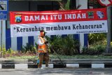 Petugas menyapu jalan di dekat spanduk berbunyi 'Damai Itu Indah, Kerusuhan Membawa Kehancuran' di Jalan Praban, Surabaya, Jawa Timur, Rabu (14/10/2020). Sejumlah spanduk yang terpasang di jalan protokol itu untuk mengajak warga menjaga kedamaian dan tidak melakukan tindakan perusakan saat berunjuk rasa. Antara Jatim/Didik/Zk