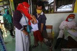 Salah satu wali murid mencoba menenangkan anaknya sebelum diimunisasi Measles Rubella (MR) saat pelaksanaan Bulan Imunisasi Anak Sekolah (BIAS) di SD Negeri Kaliasin V, Surabaya, Jawa Timur, Kamis (15/10/2020). Pemerintah Kota Surabaya menggelar Bulan Imunisasi Anak Sekolah (BIAS) dengan program imunisasi Measles Rubella (MR) dan Human Papiloma Virus (HPV) guna menjaga sistem kekebalan tubuh dari penyakit campak dan penyakit rahim. Antara Jatim/Moch Asim/zk.