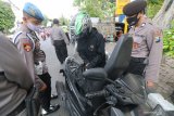 Polisi memeriksa barang bawaan pengendara sepeda motor yang dicurigai akan melakukan unjuk rasa di Kota Kediri, Jawa Timur, Kamis (15/10/2020). Razia terhadap seluruh pengendara sepeda motor berbaju hitam tersebut bertujuan mencegah warga membawa barang berbahaya dalam rencana aksi unjuk rasa tak berijin menolak Undang-undang Omnibus Law Cipta Kerja. Antara Jatim/Prasetia Fauzani/zk.