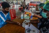 Petugas mengambil sampel darah seorang warga di posko Dinas Kesehatan (Dinkes) Provinsi Papua, Kota Jayapura, Kamis (15/10/2020). Sebanyak 16 titik posko rapid test secara gratis diadakan dalam rangka 'Kick Off' 365 hari Pekan Olahraga Nasional (PON) XX 2021, Selasa (20/10/2020) mendatang. Rapid tes ini dikhususkan bagi jurnalis/wartawan yang hendak meliput peresmian venue di Stadion Papua Bangkit serta warga yang akan menyaksikan peristiwa tersebut wajib mengantongi surat rapid test non reaktif. ANTARA FOTO/Indrayadi TH/nym.