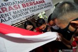 Perwakilan mahasiswa dan Siswa SMK mencium bendera merah putih saat deklarasi bersama anti anarkisme dalam penyampaian pendapat dimuka umum di halaman Kantor Walikota Blitar, Jawa Timur, Jumat (16/10/2020). Deklarasi yang diikuti oleh perwakilan organisasi mahasiswa seperti GMNI, HMI, IMM, dan PMII serta perwakilan siswa SMK/SMA tersebut guna memberikan edukasi dan pemahaman mengenai akibat dan dampak dari aksi anarkisme, pasca banyaknya sejumlah pemuda yang terlibat aksi anarkisme dalam aksi demonstrasi di beberapa daerah. Antara Jatim/Irfan Anshori/zk