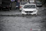 Kendaraan menerjang genangan air di Cingised, Bandung, Jawa Barat, Rabu (21/10/2020). Hujan yang mengguyur Kota Bandung sejak siang hingga sore hari membuat jalanan di kawasan tersebut tergenang air setinggi 10 hingga 30 sentimeter akibat drainase yang buruk. ANTARA JABAR/Raisan Al Farisi/agr