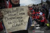 Seorang massa aksi menunjukan poster saat mengikuti aksi blokir Jalan Nasional dan Kawasan Industri di Rancaekek, Kabupaten Bandung, Jawa Barat, Kamis (22/10/2020). Dalam aksinya buruh menuntut agar Presiden Joko Widodo tidak menandatangani UU Cipta Kerja serta mendesak Presiden untuk mengeluarkan PERPPU. ANTARA JABAR/Raisan Al Farisi/agr