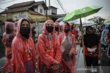 Massa aksi dari berbagai organisasi buruh menggunakan jas hujan saat mengikuti aksi blokir Jalan Nasional dan Kawasan Industri di Rancaekek, Kabupaten Bandung, Jawa Barat, Kamis (22/10/2020). Dalam aksinya buruh menuntut agar Presiden Joko Widodo tidak menandatangani UU Cipta Kerja serta mendesak Presiden untuk mengeluarkan PERPPU. ANTARA JABAR/Raisan Al Farisi/agr