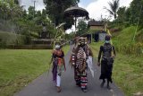 Sejumlah warga yang tubuhnya dihias warna-warni dan menggunakan masker saat berkeliling kampung dalam tradisi Ngerebeg di Desa Tegallalang, Gianyar, Bali, Kamis (22/10/2020). Tradisi yang merupakan ritual tolak bala tersebut biasanya diikuti ratusan warga, namun tahun ini digelar dengan jumlah terbatas sekitar 36 orang dengan menerapkan protokol kesehatan COVID-19. ANTARA FOTO/Nyoman Hendra Wibowo/nym.