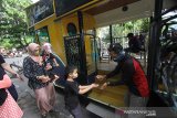 Petugas memberikan cairan antiseptik kepada wisatawan sebelum menaiki bus untuk keliling kota di Kawasan Tugu 0 Km, Banjarmasin, Kalimantan Selatan, Minggu (25/10/2020). Pemprov Kalsel bekerja sama dengan tiga asosiasi pariwisata mengoperasikan dua unit bus wisata yang diberi nama Bus Bejalanan dengan menawarkan rekreasi berkeliling Kota Banjarmasin. Hal tersebut untuk menggaet wisatawan serta membangkitkan perekonomian sektor wisata yang terpuruk akibat pandemi COVID-19. Foto Antaranews Kalsel/Bayu Pratama S.