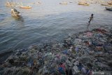 Warga kampung nelayan Nambangan beraktivitas di pinggir pantai Kenjeran yang dipenuhi sampah di Surabaya, Jawa Timur, Sabtu (24/10/2020). Menurut warga setempat, sampah-sampah tersebut selain dibawa arus hingga ke pantai juga berasal dari kebiasaan buruk masyarakat di kampung nelayan itu yang membuang sampah sembarangan. Antara Jatim/Moch Asim/zk.