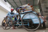 Tukang becak bersiap mendistribusikan paket Santunan Hadapi Bencana Tunai (Sahabat) kepada warga terdampak pandemi COVID-19 di Kelurahan Ngampel, Kota Kediri, Jawa Timur, Selasa (27/10/2020). Pemerintah daerah setempat membagikan bantuan sosial paket Sahabat berupa beras 10 kilogram per kepala keluarga per bulan yang didistribusikan langsung ke rumah warga oleh tukang becak dengan honor Rp5.000 per paket. Antara Jatim/Prasetia Fauzani/zk.