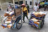 Tukang becak bersiap mendistribusikan paket Santunan Hadapi Bencana Tunai (Sahabat) kepada warga terdampak pandemi COVID-19 di Kelurahan Ngampel, Kota Kediri, Jawa Timur, Selasa (27/10/2020). Pemerintah daerah setempat membagikan bantuan sosial paket Sahabat berupa beras 10 kilogram per kepala keluarga per bulan yang didistribusikan langsung ke rumah warga oleh tukang becak dengan honor Rp5.000 per paket. Antara Jatim/Prasetia Fauzani/zk.