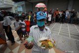 Warga memperlihatkan menu makan gratis yang didapatkan dari gerobak makanan milik Setiyono di jalan Kedungsari, Surabaya, Jawa Timur, Selasa (27/10/2020). Aksi sosial pemberian makan gratis untuk semua orang sebanyak 100 porsi setiap hari tersebut guna membantu meringankan beban ekonomi masyarakat di tengah pandemi COVID-19. Antara Jatim/Moch Asim/zk.