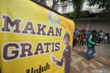 Warga mengantre untuk mendapatkan makanan secara gratis di gerobak makanan milik Setiyono di jalan Kedungsari, Surabaya, Jawa Timur, Selasa (27/10/2020). Aksi sosial pemberian makan gratis untuk semua orang sebanyak 100 porsi setiap hari tersebut guna membantu meringankan beban ekonomi masyarakat di tengah pandemi COVID-19. Antara Jatim/Moch Asim/zk.