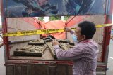 Petugas memasang garis polisi pada truk pengangkut relief makam tionghoa (bong cina) di Kota Kediri, Jawa Timur, Selasa (27/10/2020). Polresta Kediri berhasil membekuk 4 orang tersangka pencuri 25 relief pada 8 makam kuno tionghoa di pegunungan Klotok. Antara Jatim/Prasetia Fauzani/zk.