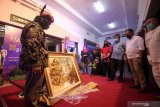 Sekretaris Daerah Provinsi Jawa Timur Heru Tjahjono didampingi Kadisbudpar Provinsi Jawa Timur Sinarto menyaksikan salah satu lukisan saat Pameran Promosi Online Harmoni Seni Rupa Jawa Timur 2020 di di Sawunggaling hall, Taman Budaya Jawa Timur, Surabaya, Jawa Timur, Selasa (27/10/2020). Pameran yang berlangsung secara luring (luar jaringan) dan daring (dalam jaringan) itu diikuti 83 perupa dari berbagai daerah di Jawa Timur. Antara Jatim/Didik/Zk