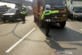 Petugas kepolisan mengatur lalu lintas kendaraan saat pemberlakuan rekayasa lalu lintas di jalan tol Jakarta - Cikampek (Japek) KM 47, Karawang, Jawa Barat, Rabu (28/10/2020). PT Jasa Marga bersama pihak kepolisian memberlakukan sistem 