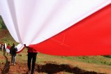 Anggota karang taruna Puriala membentangkan bendera merah putih di kaki gunung Ahuawali, Kecamatan Puriala, Konawe, Sulawesi Tenggara, Rabu (28/10/2020). Pembentangan bendera merah putih sepanjang 200 meter yang melibatkan sekitar 150 pemuda tersebut untuk memperingati hari Sumpah Pemuda. ANTARA FOTO/Jojon/nym.