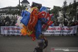 Seorang pedagang balon melintas di depan massa aksi saat unjuk rasa bela Nabi di depan Gedung Sate, Bandung, Jawa Barat, Jumat (30/10/2020). Dalam aksinya mereka mengecam pernyataan Presiden Prancis Emmanuel Macron yang diaanggap menghina Agama Islam dan menghina Nabi Muhammad. ANTARA JABAR/Raisan Al Farisi/agr