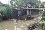 Warga membersihkan sampah yang tersangkut di pilar jembatan sungai di Kabupetan Madiun, Jawa Timur, Selasa (3/11/2020). Kegiatan membersihkan sampah yang terbawa arus sungai dari arah hulu dan tersangkut di pilar jembatan tersebut dimaksudkan untuk mencegah agar jembatan tidak roboh akibat tekanan arus sungai bila terjadi banjir. Antara Jatim/Siswowidodo/zk