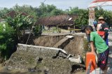 Warga melihat tangkis sungai yang ambles di Grobogan, Jiwan, Kabupaten Madiun, Jawa Timur, Selasa (3/11/2020). Menurut warga, tangkis sungai tersebut ambles akibat banjir yang terjadi Senin (2/11). Antara Jatim/Siswowidodo/zk