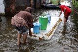 Warga korban banjir membawa air bersih di desa Kedungringin, Beji, Pasuruan, Jawa Timur, Rabu (4/11/2020). Air bersih yang disalurkan dari truk tangki bantuan dari Pemerintah Daerah setempat itu untuk warga yang kesulitan mendapatkan air bersih akibat banjir yang merendam kawasan tersebut selama lima hari. Antara Jatim/Umarul Faruq/zk