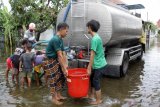 Warga korban banjir membawa air bersih yang disalurkan dari truk tangki di desa Kedungringin, Beji, Pasuruan, Jawa Timur, Rabu (4/11/2020). Bantuan air bersih dari Pemerintah Daerah setempat itu untuk warga yang kesulitan mendapatkan air bersih akibat banjir yang merendam kawasan tersebut selama lima hari. Antara Jatim/Umarul Faruq/zk