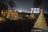 Pengunjung berada di dalam tenda saat menyaksikan film di bioskop outdoor Tenda di Bawah Bintang, Parongpong, Kabupaten Bandung Barat, Jawa Barat, Rabu (4/11/2020). Bioskop outdoor Tenda di Bawah Bintang dihadirkan untuk memenuhi keinginan masyarakat yang ingin menyaksikan pertunjukan film layar lebar dengan tetap menerapkan protokol kesehatan dan social distancing. ANTARA JABAR/M Agung Rajasa/agr