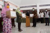 Ketua umum Forwas Eko Yudho (tengah) bersama tim CSR PT Tjiwi Kimia menyerahkan bantuan kepada warga terdampak COVID-19 di Balai Desa Ngampelsari, Kecamatan Candi, Sidoarjo, Jawa Timur, Rabu (4/11/2020). Pabrik kertas PT. Tjiwi Kimia Tbk bekerja sama dengan Forum Wartawan Sidoarjo (Forwas) menggelar bakti sosial (Baksos) sebagai upaya kepedulian terhadap warga yang terdampak Covid-19. Antara Jatim/Umarul Faruq/zk