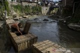Warga membersihkan keramba budi daya ikan dari sampah di aliran Sungai Cikapundung, Bandung, Jawa Barat, Jumat (6/11/2020). Sejumlah Warga di kawasan bantaran Sungai Cikapundung tersebut merawat ikan mas menggunakan keramba dari bambu sebagai pemanfaatan aliran sungai serta membantu perekonomian. ANTARA JABAR/Novrian Arbi/agr
