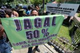 Seorang guru Madrasah membentangkan poster saat unjuk rasa di kantor Kementerian Agama (Kemenag) di Kediri, Jawa Timur, Kamis (5/11/2020). Ratusan guru dan Kepala Madrasah swasta yang bernaung di bawah Kemenag tersebut melakukan unjuk rasa menolak pemotongan dana Bantuan Operasional Sekolah (Bos) hingga 50 persen yang mengakibatkan proses pembelajaran tidak bisa maksimal karena keterbatasan anggaran milik sekolah. Antara Jatim/Prasetia Fauzani/zk