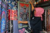 Perajin membatik pada kain katun sebagai proses pembuatan sajadah di Kelurahan Dermo, Kota Kediri, Jawa Timur, Senin (9/11/2020). Perajin batik di wilayah itu beralih membuat sajadah batik yang dijual secara daring seharga Rp110 ribu per potong guna mendongkrak penjualan seiring menurunnya permintaan kain batik akibat pandemi COVID-19. Antara Jatim/Prasetia Fauzani/zk.