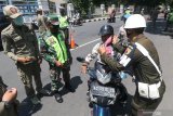 Petugas membantu memakai masker kepada pelanggar protokol kesehatan COVID-19 di Kota Kediri, Jawa Timur, Kamis (12/11/2020). Razia gabungan Polisi, TNI, dan Satpol PP tersebut diselenggaran secara berkelanjutan sebagai upaya menyadarkan masyarakat disiplin menerapkan protokol kesehatan. Antara Jatim/Prasetia Fauzani/zk