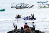 Wisatawan bermain jet ski di Pantai Solong Banyuwangi, Jawa Timur, Sabtu (14/11/2020). Olahraga jet ski menjadi salah satu destinasi wisata yang ditawarkan kepada wisatawan pecinta olahraga air. Antara Jatim/Budi Candra Setya/zk.