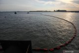 Petugas memasang 'Oil Boom' guna mengantisipasi pencemaran air laut di lokasi tenggelamnya kapal MV Mentari Crystal di Dermaga Domestik Terminal Teluk Lamong, Surabaya, Jawa Timur, Senin (16/11/2020). Kapal kargo MV Mentari Crystal yang mengangkut sekitar 137 peti kemas itu tenggelam di Dermaga Domestik Terminal Teluk Lamong pada Minggu (15/11) malam. Antara Jatim/Didik/Zk
