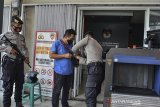 Polisi memeriksa tamu sebelum masuk ke kantor KPU Kabupaten Tasikmalaya, Jawa Barat, Senin (16/11/2020). Sejumlah logistik termasuk 1,3 juta surat suara untuk kebutuhan Pemilihan Bupati dan Wakil Bupati Tasikmalaya tiba di KPU Kabupaten Tasikmalaya dan akan didistribusikan ke 39 ke Panitia Pemilihan Kecamatan (PPK). ANTARA JABAR/Adeng Bustomi/agr