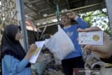 Warga menunjukkan kepingan emas saat proses penimbangan di Bank Sampah Malangbong Bersemi, Kabupaten Garut, Jawa Barat, Senin (16/11/2020). Bank sampah yang didirikan oleh warga secara mandiri tersebut merupakan inisiatif untuk menghadirkan program menabung logam mulia mini gold 0.05 gram guna menarik minat warga dan meningkatkan kesadaran tentang pemanfaatan limbah rumah tangga. ANTARA JABAR/Candra Yanuarsyah/agr