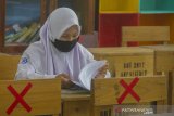 Simulasi Belajar Tatap Muka Di Kota Banjarmasin. Siswa mengikuti simulasi belajar tatap muka di SMP Negeri 7 Banjarmasin, Kalimantan Selatan, Senin (16/11/2020). Berdasarkan surat pernyataan orang tua dan persetujuan guru, Pemerintah Kota Banjarmasin melakukan simulasi belajar tatap muka pertama sejak pandemi COVID-19, selama dua minggu di empat sekolah menengah pertama (SMP) di mana lokasi sekolah berada di zona hijau berdasarkan penilaian Gugus Tugas dengan jumlah siswa terbatas serta wajib mematuhi protokol Kesehatan COVID-19. ANTARA FOTO/Bayu Pratama S.