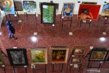 Pengunjung melihat lukisan yang dipajang dalam pameran bertajuk 