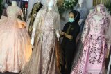 Pramuniaga menata busana pengantin yang dipajang dalam pameran perlengkapan pernikahan bertajuk 