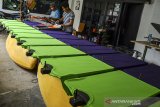 Pekerja menyelesaikan produksi pakaian di Rumah produksi CHPT di Gegernoong, Kota Tasikmalaya, Jawa Barat, Kamis (19/11/2020). Pelaku Usaha Mikro Kecil Menengah (UMKM) yang memproduksi pakaian 80-100 potong per hari, telah menerima Bantuan Produktif Usaha Mikro (BPUM) sebesar Rp2,4 juta yang digunakan untuk modal tambahan dengan berinovasi mempertahankan kualitas sablon, bahkan untuk mengembangkan pemasaran mereka bekerjasama dengan para pemilik distro pakaian agar bisa bertahan di tengah pandemi COVID-19. ANTARA JABAR/Adeng Bustomi/agr