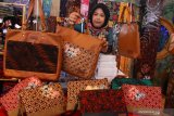 Perajin menata tas batik buatannya yang dipajang dalam Pameran Karya Kreatif Indonesia (KKI) di Malang, Jawa Timur, Jumat (20/11/2020). Pameran tersebut diadakan selama empat hari oleh Bank Indonesia untuk membantu para pelaku usaha mikro kecil menengah  (UMKM) dalam memperluas jangkauan pasar sekaligus mensosialisasikan sistem pembayaran dengan kode quick response (QR). Antara Jatim/Ari Bowo Sucipto/um