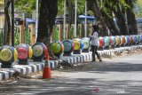 Warga swafoto di trotoar Komplek Olahraga Dadaha, Kota Tasikmalaya, Jawa Barat, Jumat (20/11/2020). Penataan trotoar jalan utama Komplek Olahraga Dadaha dihiasi ornamen bola batu dengan lukisan payung geulis sengaja dilakukan Pemerintah Kota Tasikmalaya agar tidak terkesan kumuh dan meminimalisir PKL di kawasan tersebut. ANTARA JABAR/Adeng Bustomi/agr