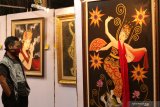 Pengunjung melihat pameran lukisan di Disbudpar Banyuwangi, Jawa Timur, Jumat (20/11/2020). Pameran yang mengangkat tema 