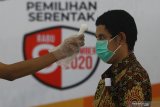 Petugas Kelompok Penyelenggara Pemungutan Suara (KPPS) memeriksa suhu tubuh warga sebelum menggunakan hak pilihnya saat simulasi pemungutan dan penghitungan suara Pilkada 2020 di Kantor KPU Kota Surabaya, Jawa Timur, Sabtu (21/11/2020). Simulasi yang diselenggarakan oleh KPU Kota Surabaya dan diikuti perwakilan Panitia Pemilihan Kecamatan (PPK) dan Panitia Pemungutan Suara (PPS) tersebut bertujuan meningkatkan pemahaman serta kemampuan petugas dalam menerapkan protokol kesehatan pada pelaksaaan pemungutan dan penghitungan suara Pilkada 2020 untuk mencegah penyebaran COVID-19. Antara Jatim/Moch Asim/mas.