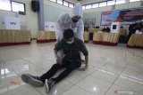 Petugas Kelompok Penyelenggara Pemungutan Suara (KPPS) berpakaian hazmat membantu seorang warga yang tiba-tiba pingsan saat simulasi pemungutan dan penghitungan suara Pilkada 2020 di Kantor KPU Kota Surabaya, Jawa Timur, Sabtu (21/11/2020). Simulasi yang diselenggarakan oleh KPU Kota Surabaya dan diikuti perwakilan Panitia Pemilihan Kecamatan (PPK) dan Panitia Pemungutan Suara (PPS) tersebut bertujuan meningkatkan pemahaman serta kemampuan petugas dalam menerapkan protokol kesehatan pada pelaksaaan pemungutan dan penghitungan suara Pilkada 2020 untuk mencegah penyebaran COVID-19. Antara Jatim/Moch Asim/zk.